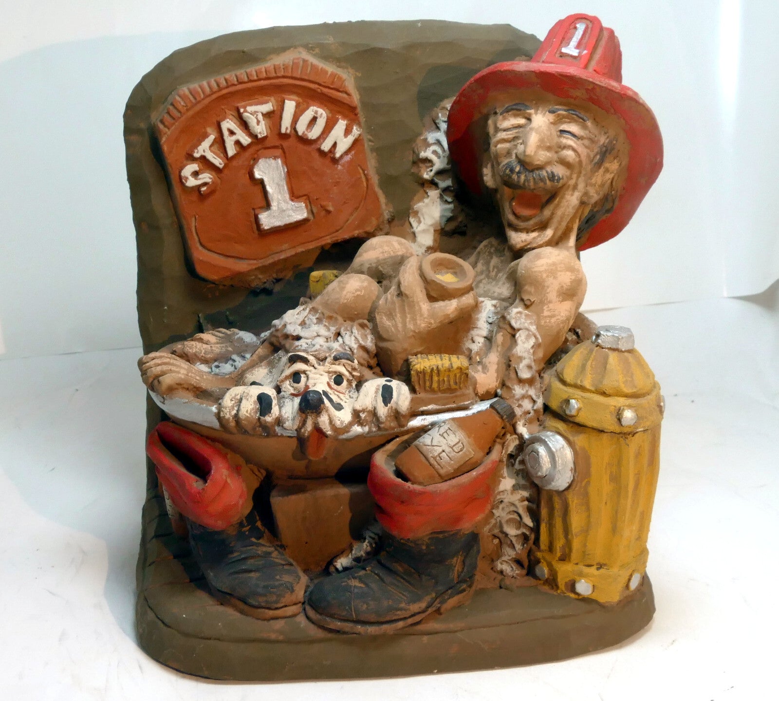 Whimsical funny clay fireman firefighter figurine with dalmatian dog in a tub